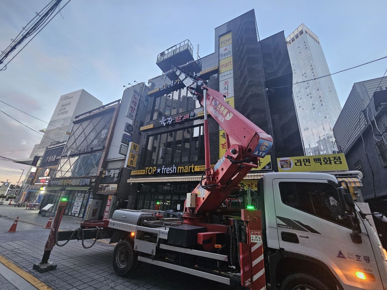 상가 건물 간판 높이까지 붐을 올린 국제크레인 스카이차